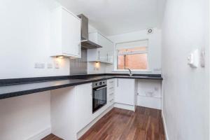 a kitchen with white cabinets and a wooden floor at Modern 2BR Apt Contractor stay in Hinckley