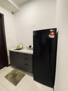 a kitchen with a black refrigerator and a sink at K Avenue with Peak Escapes A708 in Donggongon