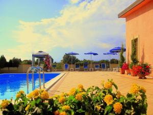 una piscina con sombrillas azules, mesas y sillas en Ferienwohnung für 3 Personen ca 32 qm in Poggio Alla Cavalla, Toskana Provinz Pistoia, en Lamporecchio