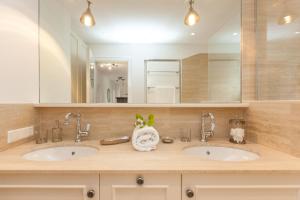 une salle de bain avec deux lavabos et un grand miroir dans l'établissement Haus See-und Säntisblick "EG", à Friedrichshafen