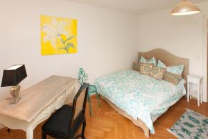 1 dormitorio con cama, mesa y escritorio en Haus See-und Säntisblick "EG", en Friedrichshafen