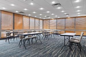 een conferentiezaal met tafels, stoelen en ramen bij AmericInn by Wyndham Casper Event Center Area in Casper