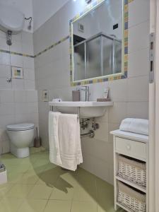 uma casa de banho com um lavatório, um WC e um espelho. em CASA ORNETO em Poggibonsi