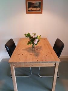 een houten tafel met een vaas met bloemen erop bij Houterhoeve in Swalmen