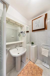 een witte badkamer met een wastafel en een douche bij Residence Giardino 3 by Wonderful Italy in Soiano del Lago