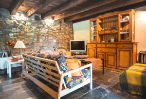 een kamer met een bed, een tv en een stenen muur bij Ferienwohnung für 4 Personen ca 50 qm in Carucedo, Kastilien-Leon Provinz Len in Carucedo