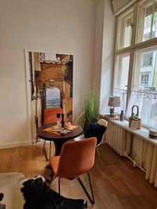 - un salon avec une table, des chaises et un miroir dans l'établissement Appartement Berlin Charlottenburg, à Berlin