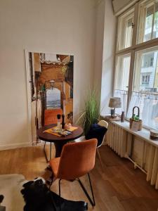 a living room with a table and chairs and a mirror at Appartement Berlin Charlottenburg in Berlin