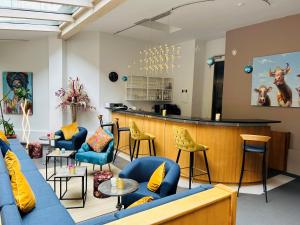 a lobby with a blue couch and chairs and a bar at Hotel Wendelstein in Rosenheim
