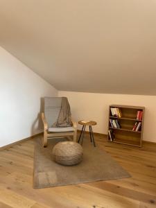 krzesło i stołek w pokoju z dywanem w obiekcie Ferienhaus Gann - Greit w mieście Villanders