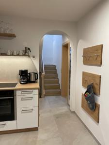 a kitchen with an archway leading to a staircase at Ferienhaus Gann - Greit in Villandro