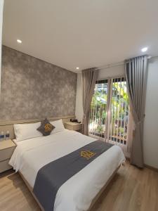 Un dormitorio con una cama grande y una ventana en Kim Đồng homestay, en Buôn Enao