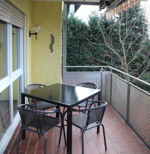 einen schwarzen Tisch und Stühle auf dem Balkon in der Unterkunft Wohnung in Lützelsachsen in Weinheim