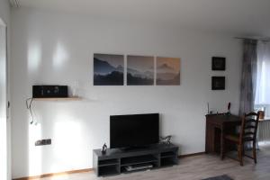 ein Wohnzimmer mit einem Flachbild-TV und einem Tisch in der Unterkunft Wohnung in Lützelsachsen in Weinheim