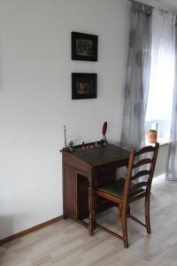 un escritorio de madera con una silla junto a una ventana en Wohnung in Lützelsachsen, en Weinheim