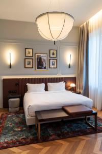 a bedroom with a large bed and a large chandelier at Radisson Collection Hotel, Palazzo Touring Club Milan in Milan