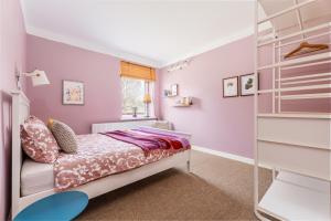 um quarto com paredes roxas, uma cama e uma prateleira em Art&Comfort Country em Kaunas