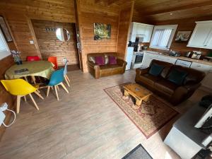 a living room with a couch and a table at Wye View Lodge, Hay View Lodges in Hereford