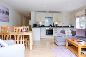 a living room and kitchen with a couch and a table at Goldfinch Lodge in Droitwich