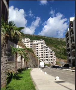 a building on the side of a street with a mountain at RS lux Becici in Becici
