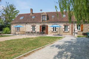 una casa di mattoni con ombrelli blu davanti di Crazy Villa Champs Corons 61 - Interior heated pool - 2h from Paris - 30p a Les Menus