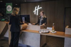 deux femmes inscrites à un registre de caisse dans un magasin dans l'établissement Holiday Inn Lübeck, an IHG Hotel, à Lübeck