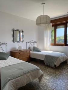 a bedroom with two beds and a mirror and a window at Villa Rosana in Naveces