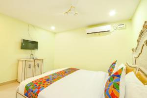 a bedroom with a bed and a television in it at FabHotel Prime JVS Beauty Green Resorts in Venkatāpur