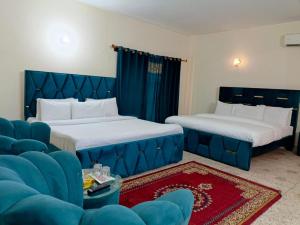 イスラマバードにあるLuxury Moon Guest Houseのベッド2台とソファが備わるホテルルームです。