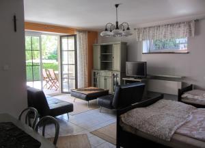 a living room with a bed a desk and a tv at Willa w Ogrodzie in Sandomierz