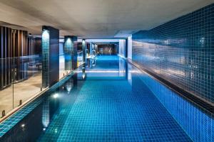 uma piscina com azulejos azuis num edifício em Central 1-Bed with Pool Sauna Gym and Parking em Camberra