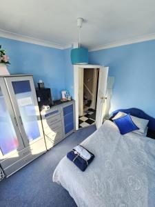 a bedroom with a bed and a blue wall at Single Unique Room For Professionals in Ealing