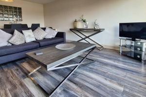 - un salon avec un canapé et une table dans l'établissement Modern 3 bedroom apartment with city river views, à Dublin