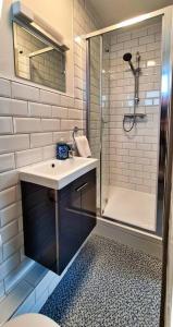 La salle de bains blanche est pourvue d'un lavabo et d'une douche. dans l'établissement Modern 3 bedroom apartment with city river views, à Dublin