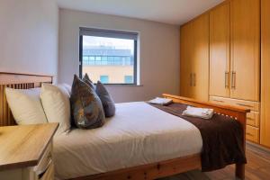 a bedroom with a large bed with a window at Modern 3 bedroom apartment with city river views in Dublin