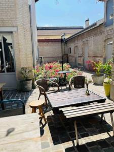 an outdoor patio with a wooden table and chairs at Appartement duplex cosy in Cormicy