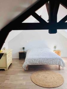 a bedroom with a bed and a dresser and a rug at Appartement duplex cosy in Cormicy