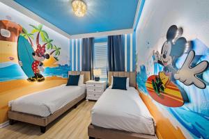 a bedroom with two beds with a mural on the wall at 3141 Paradox Circle 406 in Kissimmee +43 photos