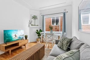 - un salon avec un canapé et une télévision dans l'établissement Bondi 2-Bed Apartment with Awesome Sunrise Views, à Sydney