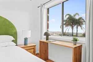 - une chambre avec un lit et une fenêtre bordée de palmiers dans l'établissement Bondi 2-Bed Apartment with Awesome Sunrise Views, à Sydney