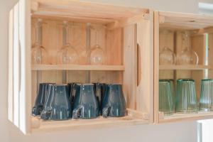 a cupboard filled with glass vases and wine glasses at Kormoran - a59405 in Ueckeritz