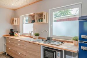 a kitchen with a desk with a keyboard and two windows at Kormoran - a59405 in Ueckeritz