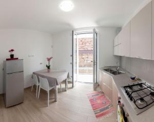 een witte keuken met een tafel en een tafel en stoelen bij Ferienwohnung für 4 Personen ca 80 qm in Lezzeno, Comer See Südufer Comer See in Lezzeno