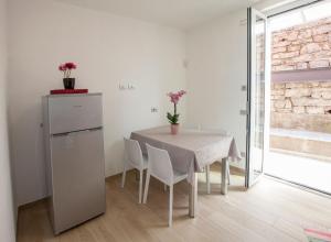 een witte eetkamer met een tafel en stoelen bij Ferienwohnung für 4 Personen ca 80 qm in Lezzeno, Comer See Südufer Comer See in Lezzeno