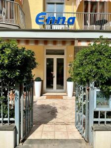 une entrée à un bâtiment avec un panneau sur celui-ci dans l'établissement Hotel Enna Rimini, à Rimini