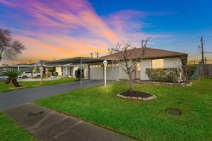 a house with a tree in the front yard at Covered Back Patio Covered Parking Game Room WIFI Smart TV's every room Washer & Dryer in Pasadena