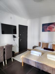 1 dormitorio con cama, mesa y TV en Hotel City Rooms Prishtina en Pristina