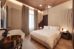1 dormitorio con cama y bañera en Zenith Premium Suites, en Tesalónica