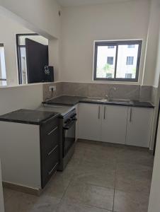 a kitchen with a sink and a stove top oven at Viwak Homes in Mombasa