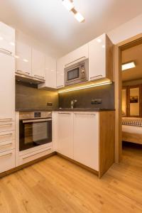 a kitchen with white cabinets and a microwave at Neue Ferienwohnung in Mittersill mit Grill, Garten und Terrasse in Mittersill